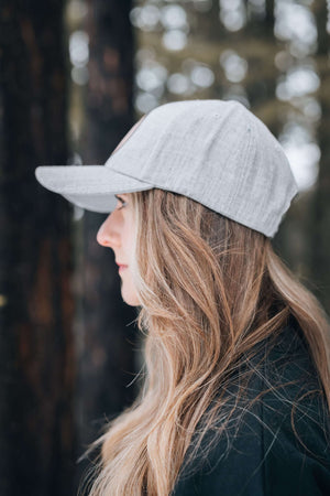 Woman wearing a Snowboarder, Trucker Hat in a natural setting, showcasing its stylish design.