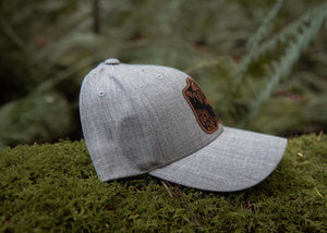 Hiking Boot, Trucker Hat on mossy ground in the forest, designed in Canada, outdoor hat for women.