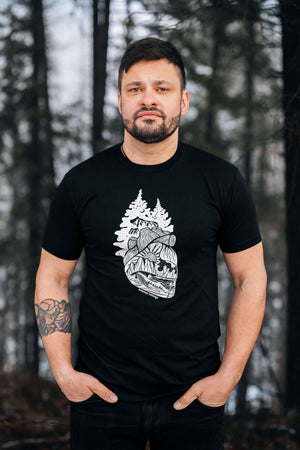 Forest Heart, Unisex T-shirt, Responsibly Made displayed by a model in a forest setting, featuring outdoor illustrations.