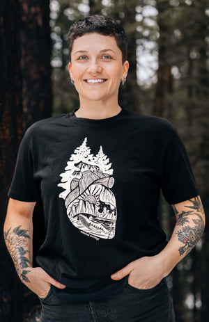 Model wearing Forest Heart, Unisex T-shirt, Responsibly Made featuring outdoor illustrations, designed in Canada.