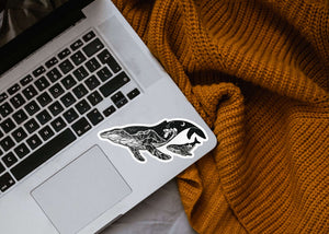 Little Whale Sticker on a laptop, showcasing an original illustration in black and white, made in Canada.