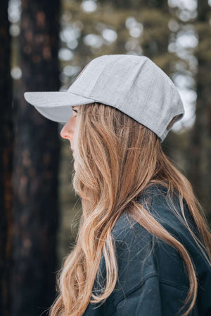 Moon and Climber Trucker Hat worn by a woman outdoors, showcasing style for adventures.