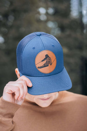 Skier, Trucker Hat featuring durable faux leather patch, perfect outdoor hat for women, designed in Canada.
