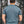 Back view of a man wearing a Salmon, Unisex T-shirt, Responsibly Made in a forest setting.