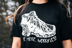 Hike More, Worry Less; Unisex T-shirt, Responsibly Made featuring outdoor illustrations on a black tee.