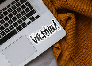 Victoria Sticker on a laptop, featuring a glossy vinyl finish and original black and white illustration.