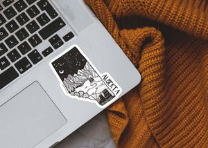 Alberta Sticker on a laptop, featuring an outdoor design with black and white original illustration, made in Canada.