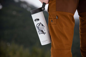 Bear & Salmon Sticker on a travel mug, perfect outdoor sticker for adventurous spirits.