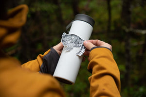Bison Sticker on a white insulated tumbler outdoors, featuring an original black and white illustration by a Canadian artist.