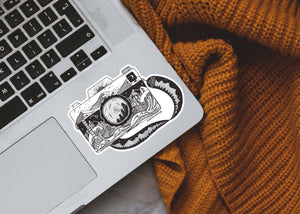 Camera Sticker on a laptop, featuring original black and white illustration, made in Canada, glossy vinyl outdoor sticker.