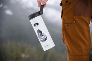 Campfire Sticker on a sleek white travel mug, perfect outdoor sticker designed by a Canadian artist.