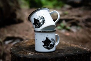 Fox Enamel Mug stacked on woodland stump, showcasing original illustration by Canadian artist.