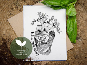 A front side of a plantable seed greeting card with a black and white illustration of anatomical heart and with text "follow your heart" on the left side of the illustration.