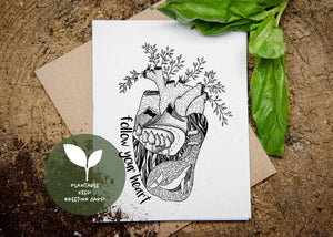 A front side of a plantable seed greeting card with a black and white illustration of anatomical heart and with text "follow your heart" on the left side of the illustration.