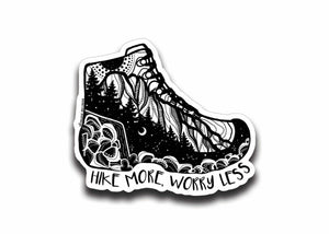 Hike More, Worry Less Sticker featuring a black and white illustration of a hiking boot on a glossy vinyl finish.