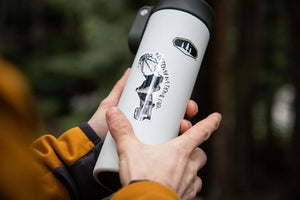 Kootenay National Park Sticker on a travel mug held by a person in outdoor setting.