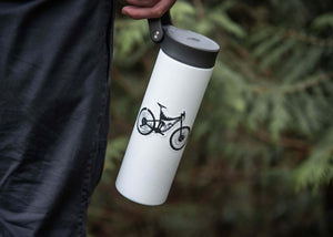 Mountain Bike Sticker on a white stainless steel water bottle in outdoor setting.