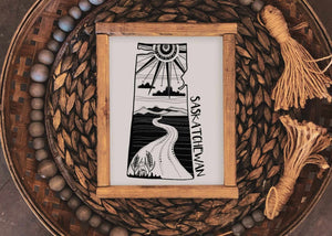 Saskatchewan Print in a wooden frame, featuring black and white illustrations of landscapes, eco-friendly art print.