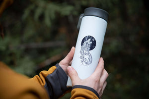 Person holding a travel mug featuring a Sea Wolf Sticker with black and white original illustration.