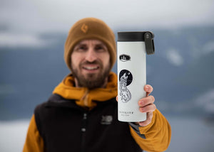 Man holding a travel mug featuring a Sea Wolf Sticker, an outdoor sticker with black and white original illustration.
