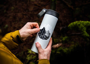 Person holding a travel mug featuring a Sleeping Fox Sticker, showcasing outdoor adventure themes and original illustration.