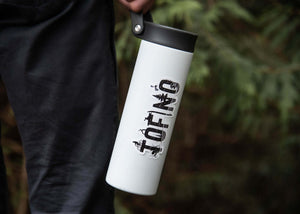 Tofino Sticker on a stylish travel mug outdoors, showcasing black and white original illustration by a Canadian artist.