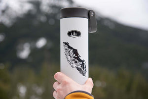 Vancouver Island Sticker on a travel mug in a mountain setting, featuring original black and white illustration.