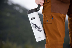 Vancouver Island Sticker on a white insulated tumbler held by a person dressed in outdoor gear, showcasing outdoor vibes.