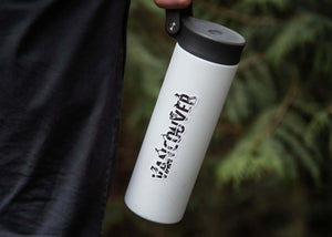 Vancouver Sticker on a reusable white travel mug held outdoors, showcasing an original black and white illustration.