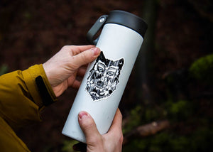 Wolf Head Sticker on a travel mug, showcasing an original illustration by a Canadian artist, made of durable vinyl.